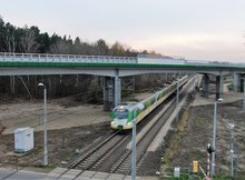 Mokra Wieś - wiadukt nad torami dołem jedzie pociąg, fot. Artur Lewandowski PKP Polskie Linie Kolejowe SA