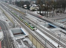 Skrzyżowanie bezkolizyjne w Kobyłce, widać pociąg, jezdnię i ścieżkę rowerową w tunelu pod torami, fot. A.Lewandowski, P.Mieszkowski