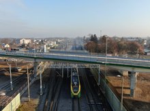 Wiadukt nad torami w Tłuszczu, dołem jedzie pociąg, fot. Artur Lewandowski PKP Polskie Linie Kolejowe SA (2)